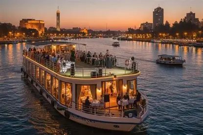 Beit Khufu – Nile Dinner Cruise A lit-up dinner cruise boat on the Nile in Cairo at dusk